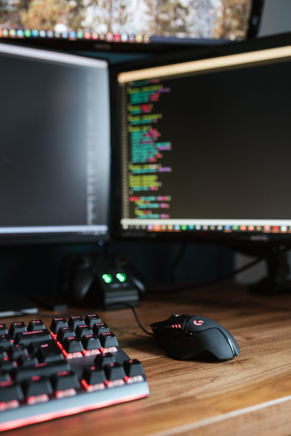My desk: dual monitors with a code editor open, a backlit mechanical keyboard and a gaming mouse